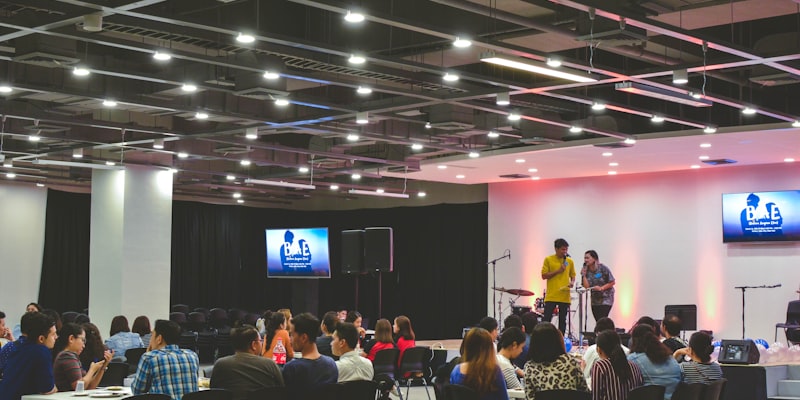 关于我们团队合影 - 一群充满热情的团队成员在现代化的办公室内，背景有足球和播放设备